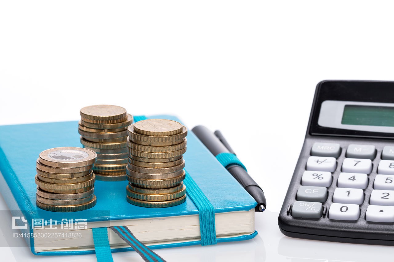 白色背景上的硬币和计算器Stack Of Coins And Calculator Over White Background